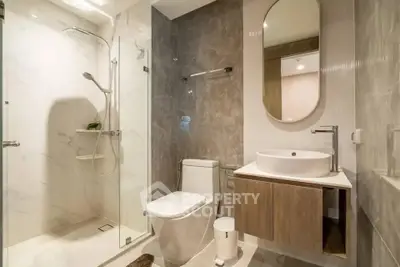 Modern bathroom with glass shower, elegant fixtures, and stylish design.