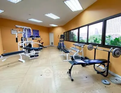 Spacious gym with modern equipment and city view windows