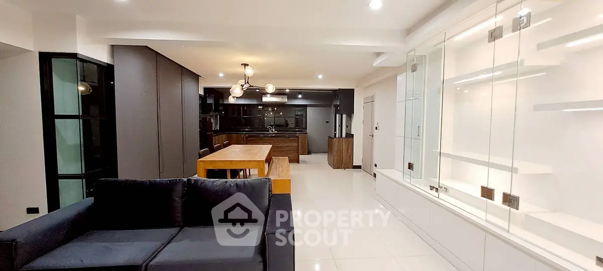 Modern open-plan living room with sleek kitchen and stylish lighting