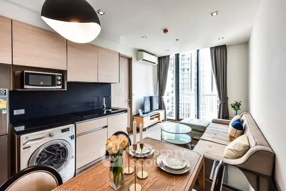 Modern living room with open kitchen, featuring sleek appliances and stylish decor in a high-rise apartment.