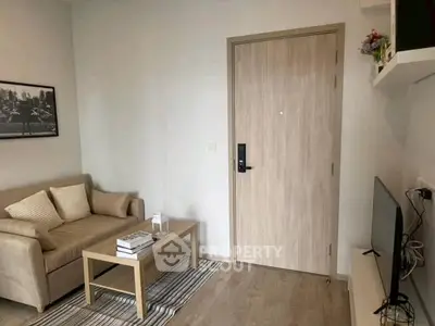 Cozy living room with modern decor and wooden flooring, featuring a comfortable sofa and stylish coffee table.