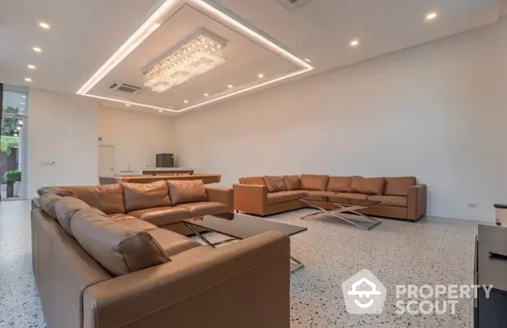 Spacious modern living room with elegant lighting and comfortable leather sofas