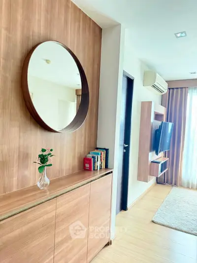 Modern living room with wooden accents, wall-mounted TV, and large mirror reflecting natural light.