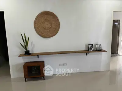 Minimalist interior with wall-mounted shelf and decor accents in modern living space.