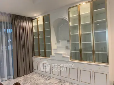Elegant living room with built-in glass cabinets and marble flooring