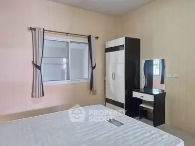 Spacious bedroom with modern wardrobe and vanity in a well-lit apartment.