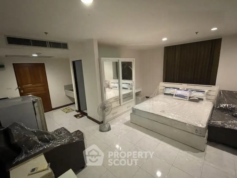 Spacious modern bedroom with sleek furniture and ample lighting, perfect for comfortable living.