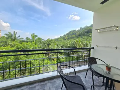 Spacious balcony with stunning green view, perfect for relaxation and outdoor dining.