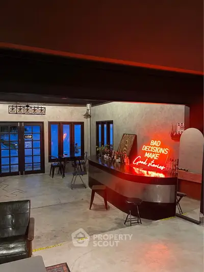 Stylish modern bar area with neon sign and cozy seating