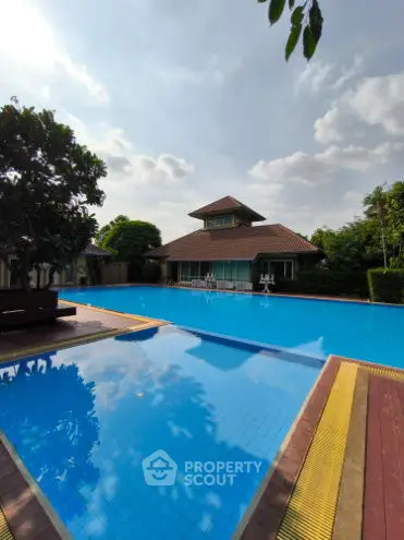Stunning residential pool area with clear blue water and lush greenery.