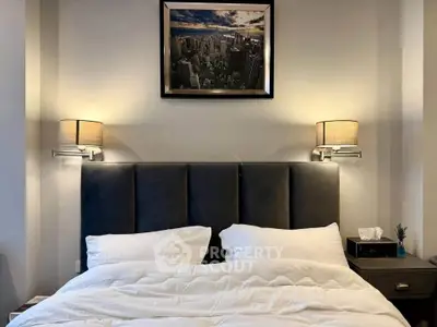 Elegant bedroom with plush headboard and stylish wall lamps, perfect for relaxation.