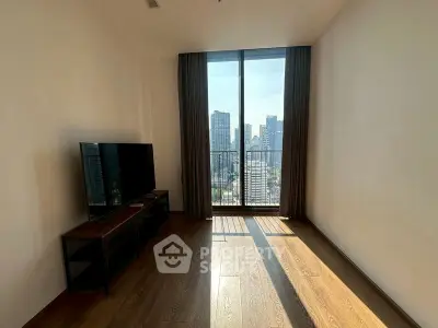 Spacious living room with large window offering stunning city views and abundant natural light.