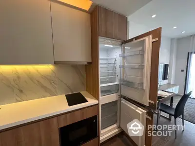 Modern kitchen with open fridge and sleek cabinetry in a stylish apartment