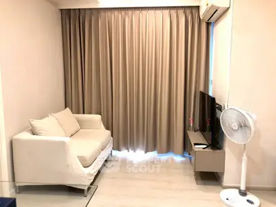 Cozy living room with sofa, TV, and air conditioning, perfect for relaxation.