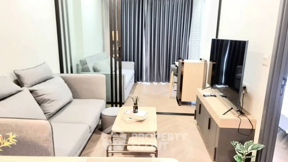 Modern living room with stylish furniture and large TV, perfect for relaxation.