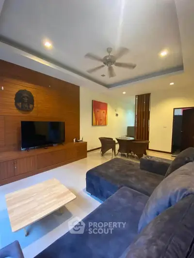 Spacious living room with modern decor and ceiling fan
