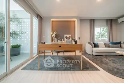Modern living room with stylish decor and large windows offering natural light.