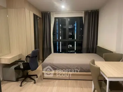 Modern bedroom with sleek furniture and large window in urban apartment