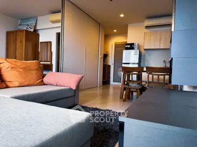 Modern open-plan living room with cozy seating and stylish kitchen area.