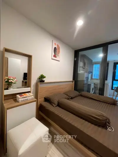 Modern bedroom with stylish decor and adjacent laundry area in a cozy apartment.