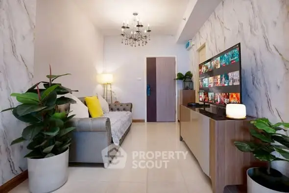 Modern living room with stylish decor and large TV, perfect for entertainment.