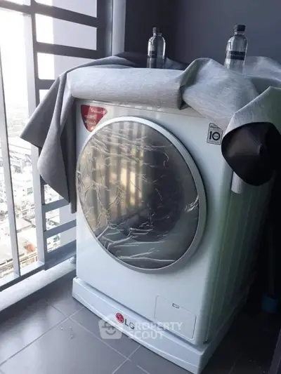 Modern washing machine on a balcony with city view, perfect for urban living convenience.