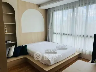 Modern bedroom with large window and minimalist design, featuring built-in shelves and cozy bedding.