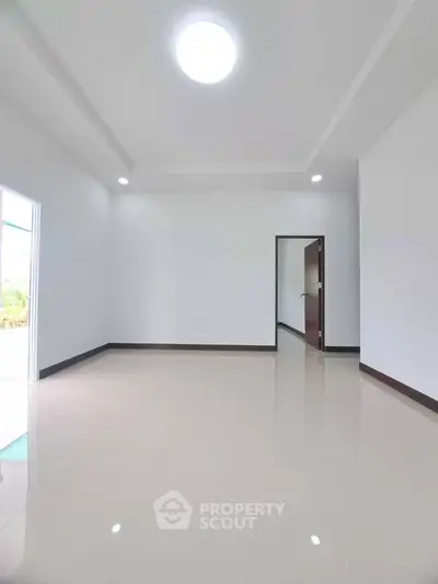 Spacious empty room with glossy tiled floor and modern ceiling lights