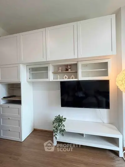 Modern living room with sleek white cabinetry and mounted TV, perfect for stylish urban living.
