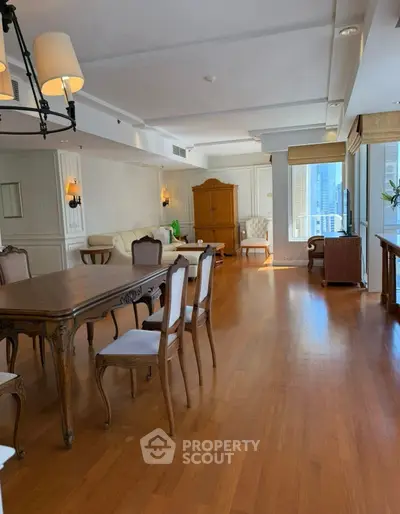 Spacious living room with elegant wooden furniture and large windows offering city views.