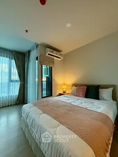 Cozy bedroom with modern decor and natural light in a stylish apartment.