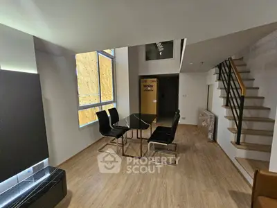 Modern duplex living room with sleek dining area and staircase