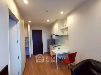 Modern apartment interior with open kitchen and dining area, featuring sleek design and cozy ambiance.