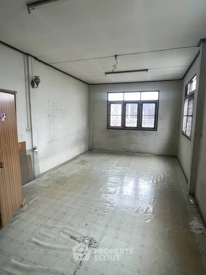 Spacious empty room with large windows and tiled floor, ideal for customization.