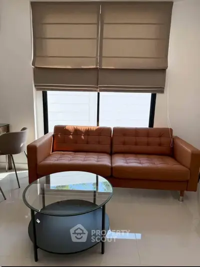 Modern living room with stylish brown sofa and glass coffee table, perfect for contemporary homes.