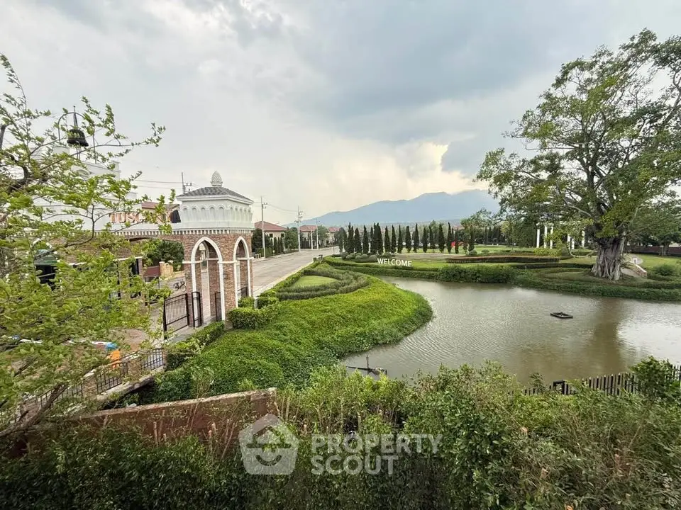 Scenic view of a picturesque estate entrance with lush greenery and tranquil pond.