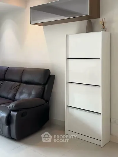 Modern living room with sleek white storage and comfortable leather sofa