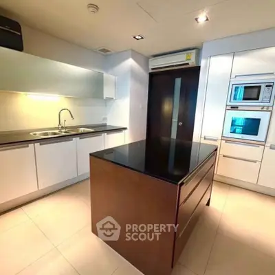 Modern kitchen with sleek cabinetry and island in luxury apartment