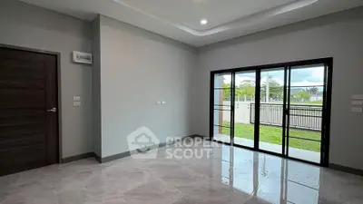 Spacious modern living room with large windows and garden view, perfect for natural light lovers.
