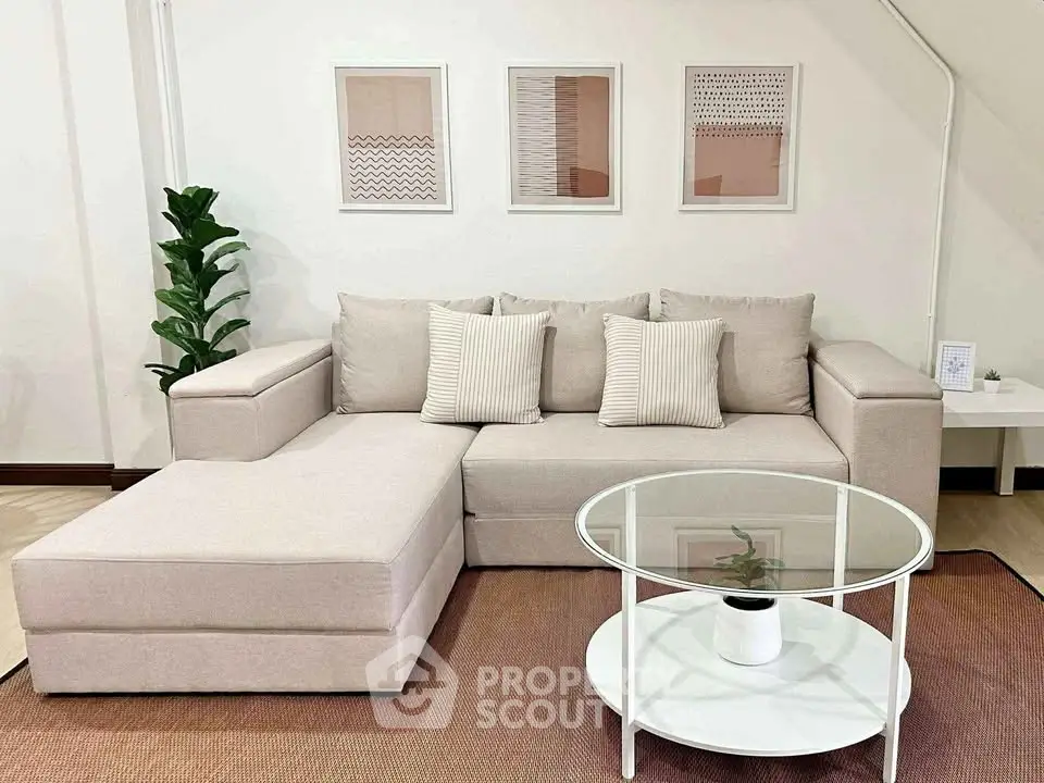 Stylish living room with modern beige sectional sofa and glass coffee table, perfect for relaxation.
