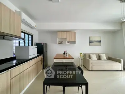 Modern open-layout kitchen and living area with sleek design and neutral tones.