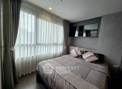 Cozy bedroom with large window and modern decor in a stylish apartment.