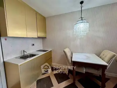 Elegant kitchen with gold cabinets and chic dining area featuring a crystal chandelier.