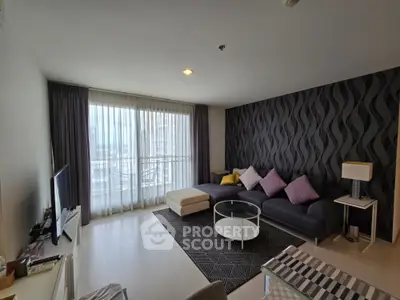 Modern living room with stylish decor and large window offering natural light and city view.