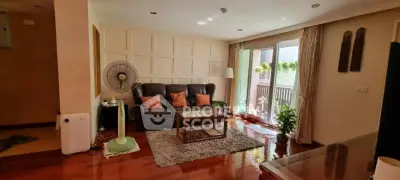 Spacious living room with elegant decor and balcony access, featuring cozy seating and natural light.