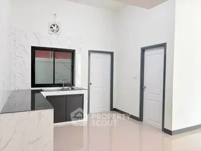 Modern kitchen with sleek black and white design, featuring a closed layout and stylish cabinetry.