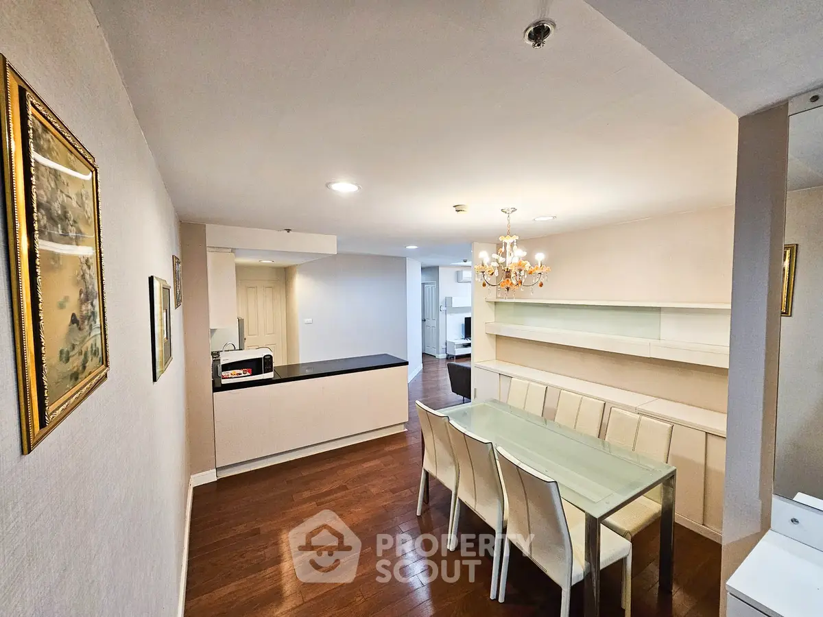 Elegant dining area with glass table and chandelier in modern apartment
