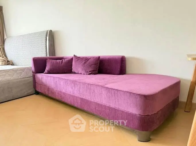 Stylish modern bedroom with plush purple sofa and elegant bed frame