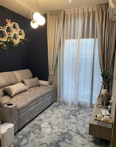 Cozy living room with plush sofa, modern lighting, and floor-to-ceiling curtains in a stylish apartment.