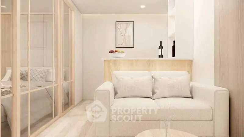 Modern living room with cozy sofa and stylish decor adjacent to a bedroom with glass partition.